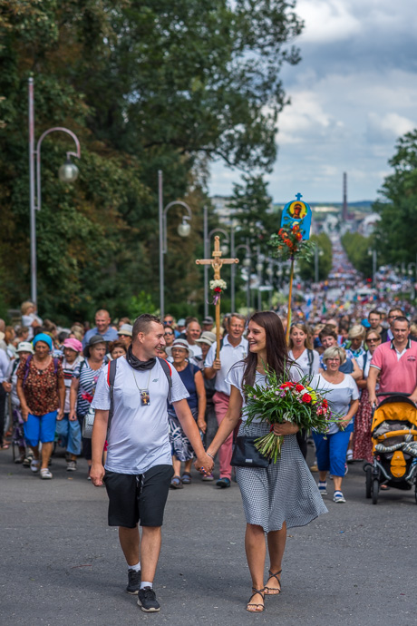 couple walks hand in hand in front of a group of pilgrims. Image: Michel Meijer