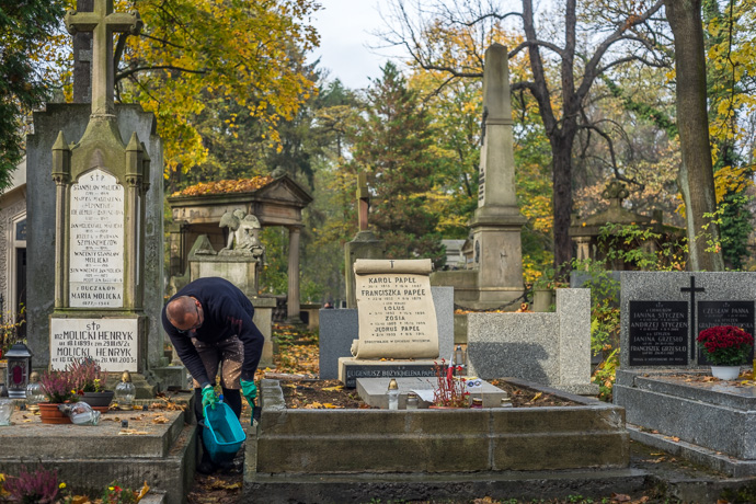 A man cleans a grave, All Saints' Day in Poland. Image: Michel Meijer
