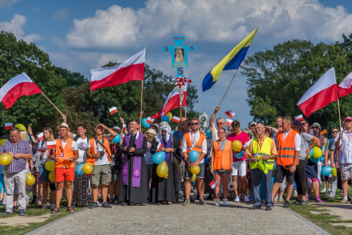 A group of pilgrims stands in front of the Jasna Góra monastery and waves to the priest on the balcony. Image: Michel Meijer