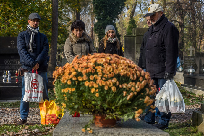 Relatives are standing around a grave with flowers and candles, All Saints' Day in Poland. Image: Michel Meijer