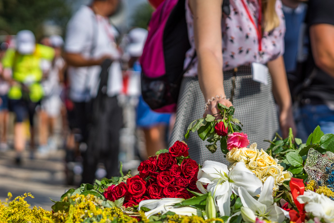 A woman lays flowers on a monument in front of the Jasna Góra pilgrimage site. Image: Michel Meijer