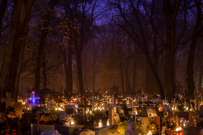 Gravestones in a cemetery are lit by candles, All Saints' Day in Poland. Image: Michel Meijer