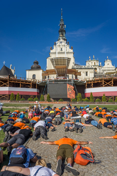 A group of pilgrims lies on the ground in front of the Jasna Góra pilgrimage site. Image: Michel Meijer
