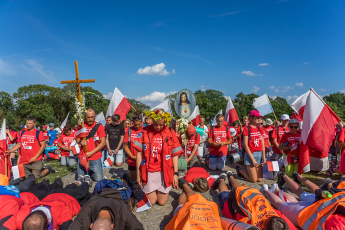 A group of pilgrims kneels and prays in front of the Jasna Góra pilgrimage site. Image: Michel Meijer