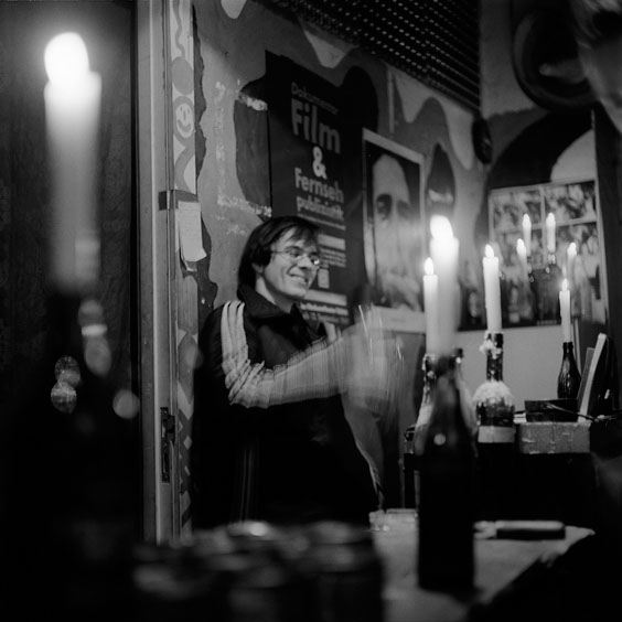 An staff member prepares the drinks in the reception area of the cinema. The reception area is lit by many candles. Image: Michel Meijer