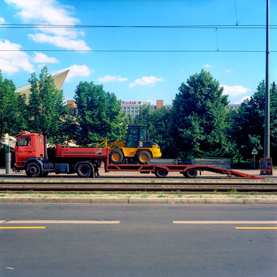A yellow bulldozer on a red trailer in a street in Berlin. Image: Michel Meijer