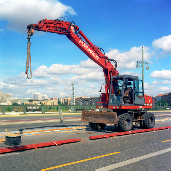 A red excavator on a street in Berlin. Image: Michel Meijer