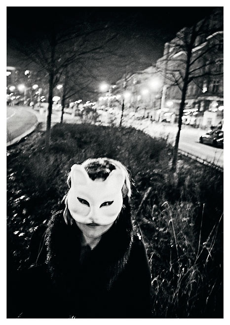 Eine Frau mit einer Katzenmaske auf den Straßen von Berlin. Das Foto wurde von Christian Reister aufgenommen.