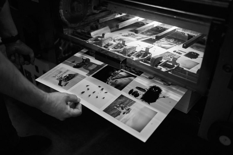 Der Drucker nimmt einen Druckbogen zur Überprüfung aus der Druckmaschine.