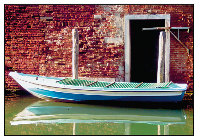 Ein Boot liegt in einem der Kanäle Venedigs an der Pier. Foto: Adi Garbers.